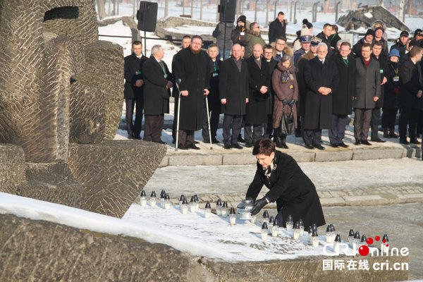  波兰总理希德沃在纪念碑前点燃蜡烛
