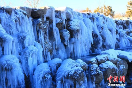 寒冬时节，雪后初晴，地处甘肃河西走廊的张掖市滨河新区人工湖被白雪覆盖，涓涓细流形成晶莹剔透的冰瀑、冰挂，成为冬日一景。 陈礼 摄