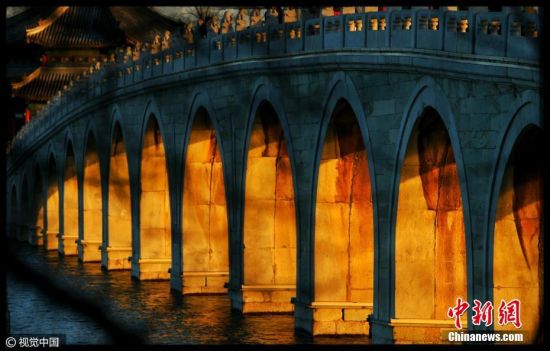 2016年12月28日，北京，建造颐和园的设计师经过精心计算，使十七孔桥与南回归线的日落点呈垂直状态，所以每年冬至前后几天里，落日的余晖将全部照亮十七孔桥的所有17个孔洞，呈现出壮丽景观。李建泉 摄 图片来源：视觉中国