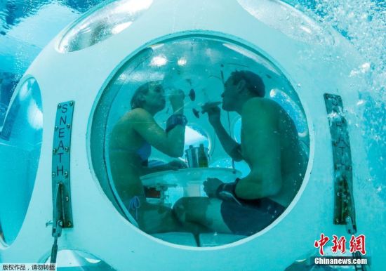 当地时间2017年1月30日，比利时布鲁塞尔，Nicolas Mouchart 和Florence 穿上了潜水装备和脚蹼，潜入水下餐厅“珍珠”用餐。比利时首都布鲁塞尔的 Nemo33 泳池是全球最深的游泳池，深达33米，位于水面五米以下，正是著名的水下餐厅“The Pearl(珍珠)”，珍珠餐厅形似一个两米宽的白色球形吊舱，悬浮在水中接近池底。食客们只需脱下配重腰带，便能直接游进“吊舱” 。